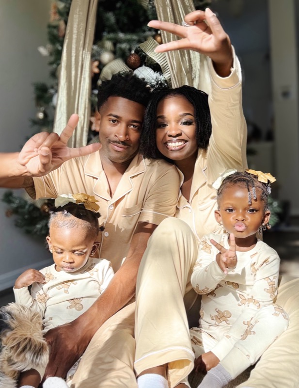 Janiece and her family in matching pajamas by the Christmas tree