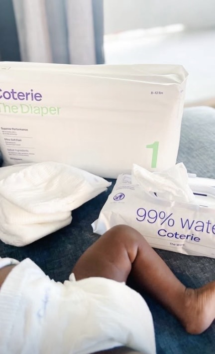Coterie diaper and wipes laid out next to a baby's foot