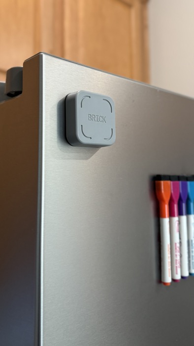 A Brick device mounted on a refrigerator