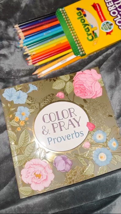 Color & Pray Proverbs coloring book next to colored pencils